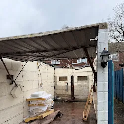 Moss-covered asbestos garage roof before removal
